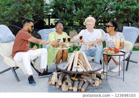 Friends celebrating outside, drinking wine and eating fruit on a picnic Friends celebrating outside, drinking wine and eating fruit on a picnic 123696103