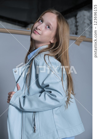 Young model looking over her shoulder, a playful yet stylish moment. Ideal for casual fashion and kids lifestyle segments. Young model looking over her shoulder, a playful yet stylish moment. Ideal for casual fashion and kids lifestyle segments. 123696155