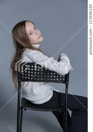Child looking back with a serene expression, comfortably dressed in winter wear. Reflects quiet confidence and cozy trends. Child looking back with a serene expression, comfortably dressed in winter wear. Reflects quiet confidence and cozy trends. 123696189