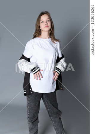 A girl in a casual varsity jacket looks straight ahead, projecting confidence and self-assurance. Her stance symbolizes the emerging identity and independence of today s young generation. A girl in a casual varsity jacket looks straight ahead, projecting confidence and self-assurance. Her stance symbolizes the emerging identity and independence of today s young generation. 123696263