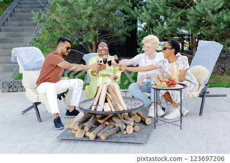 Friends celebrating outside, drinking wine and eating fruit on a picnic 123697206