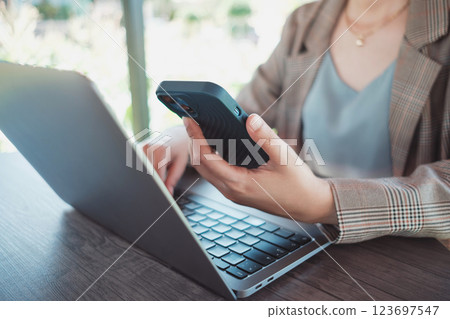 Close up female hands using smartphone shopping online, Freelancer remote working from coffee shop. 123697547