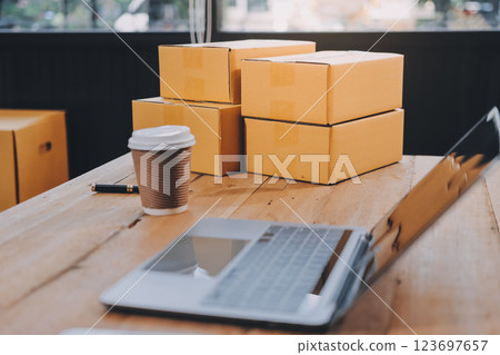 Asian SME business women use laptop computer checking customer order online shipping boxes at home. Starting Small business entrepreneur SME freelance. Online business, Work at home concept. Asian SME business women use laptop computer checking customer order online shipping boxes at home. Starting Small business entrepreneur SME freelance. Online business, Work at home concept. 123697657