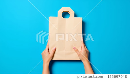 Go to page |123Next Hands holding a light beige paper shopping bag 123697948