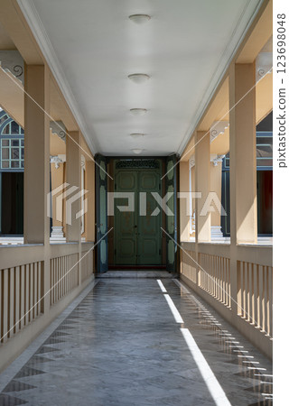 Perspective view of Long corridor with lantern ceiling and columns leading into entrance green ancient door. Perspective view of Long corridor with lantern ceiling and columns leading into entrance green ancient door. 123698048
