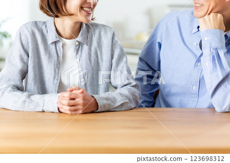 A middle-aged couple having a pleasant conversation in the living room A middle-aged couple having a pleasant conversation in the living room 123698312
