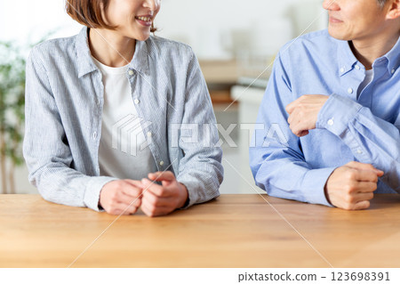 A middle-aged couple having a pleasant conversation in the living room A middle-aged couple having a pleasant conversation in the living room 123698391