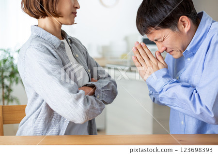 A middle-aged couple in the living room, with the husband making a request and the wife getting angry 123698393