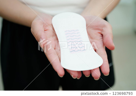 Asian woman holding sanitary napkin pad for hygiene menstrual period cycle protection. 123698793