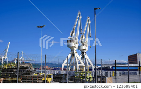 Two cranes are in the background of a blue sky Two cranes are in the background of a blue sky 123699401