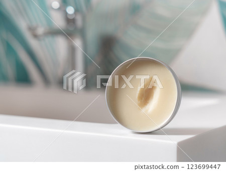 Opened body butter jar on washbasin in green tropical bathroom close up, herbal cosmetic mockup 123699447