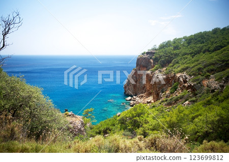 Stunning coastal cliff view with crystal-clear blue sea and lush green hillside Stunning coastal cliff view with crystal-clear blue sea and lush green hillside 123699812