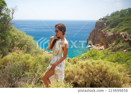 Woman in summer dress enjoying coastal cliff view 123699856
