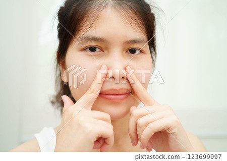 Asian woman receiving plastic surgery shape of nose performed on face. 123699997