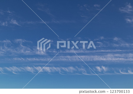 Bright blue sky with a minimum of clouds, calm and serene. 123700133