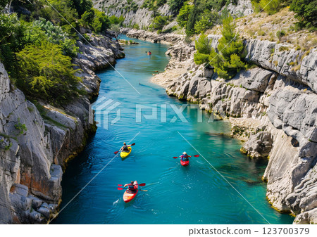 Group people of kayaking on narrow river between rocky mountains on sunny summer day.AI Generative. 123700379
