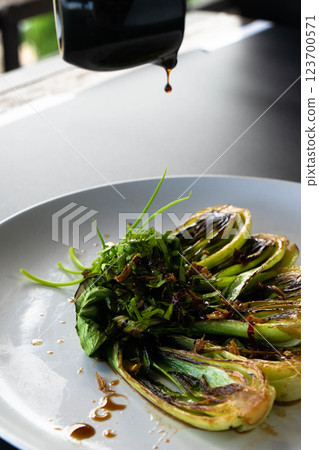 Bok choy is dressed with herbs and sauce, creating a colorful and tasty dish. 123700571