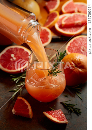 Grapefruit juice is poured into a glass. 123700954