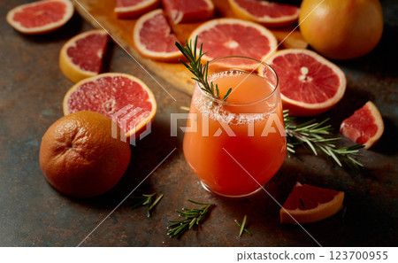 A glass of grapefruit juice garnished with a rosemary sprig. A glass of grapefruit juice garnished with a rosemary sprig. 123700955