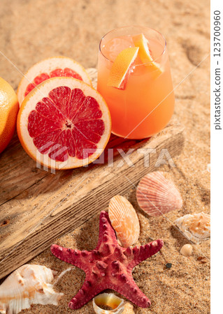 Grapefruit cocktail with ice on a beach. Grapefruit cocktail with ice on a beach. 123700960