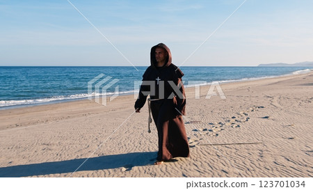 Christian Priest Walking Barefoot On The sandy beach Christian Priest Walking Barefoot On The sandy beach 123701034