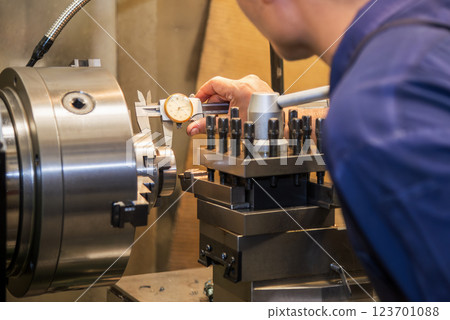 Close up scene the machine operator measuring dimension of turning parts by dial Vernier caliper. Close up scene the machine operator measuring dimension of turning parts by dial Vernier caliper. 123701088