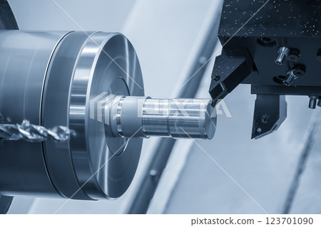The  CNC lathe machine forming  cutting the metal shaft parts in the light blue scene. 123701090