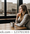young woman drinking a cup of coffee 123701303