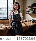 smiling waitress standing with arms crossed in cafe 123701304