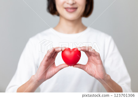 微笑的中年婦女手持心形符號 微笑的中年婦女手持心形符號 123701306