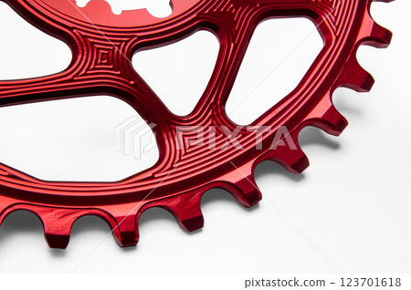 Close up of a red oval bicycle chainring against white isolated background. Professional bicycle part. Close up of a red oval bicycle chainring against white isolated background. Professional bicycle part. 123701618