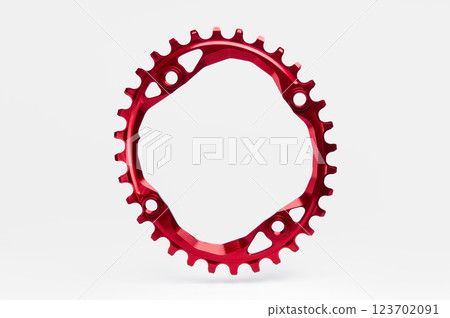 Red oval bicycle chainring against white isolated background, floating above the surface. Professional bicycle part. 123702091