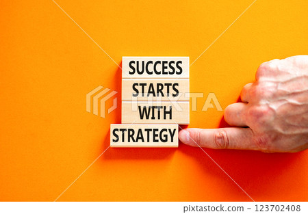 Success starts with strategy symbol. Concept words Success starts with strategy on beautiful wooden blocks. Beautiful orange background. Business and success starts with strategy concept. Copy space. Success starts with strategy symbol. Concept words Success starts with strategy on beautiful wooden blocks. Beautiful orange background. Business and success starts with strategy concept. Copy space. 123702408