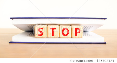 Stop symbol. Concept word Stop on beautiful wooden blocks in book. Beautiful wooden table white background. Business, lifestyle, support and stop concept. Copy space. 123702424