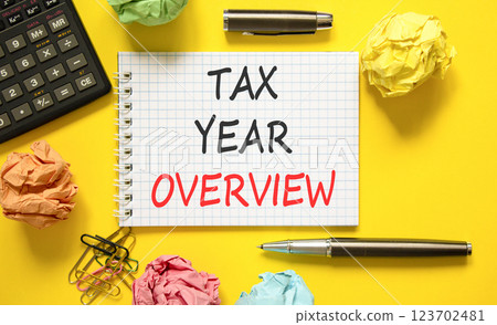 Tax year overview symbol. Concept words Tax year overview on beautiful white note. Beautiful yellow background. Black pen. Black calculator. Business tax year overview concept. Copy space. 123702481