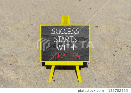 Success starts with strategy symbol. Concept words Success starts with strategy on beautiful blackboard. Beautiful sand background. Business and success starts with strategy concept. Copy space. Success starts with strategy symbol. Concept words Success starts with strategy on beautiful blackboard. Beautiful sand background. Business and success starts with strategy concept. Copy space. 123702533