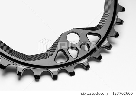 Close up of a black oval bicycle chainring against white isolated background, lies flat on the surface. Professional bicycle part. 123702600