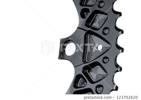 Close up of a black oval bicycle chainring against white isolated background, lies flat on the surface. Professional bicycle part. 123702620