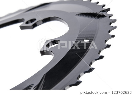 Close up of a black oval bicycle chainring against white isolated background, lies flat on the surface. Professional bicycle part. 123702623