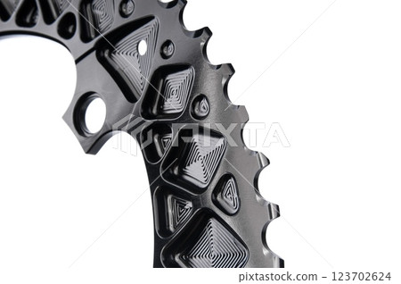 Close up of a black oval bicycle chainring against white isolated background, lies flat on the surface. Professional bicycle part. 123702624