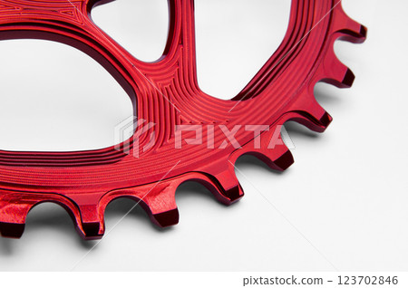Close up of a red oval bicycle chainring against white isolated background, lies flat on the surface. Professional bicycle part. Close up of a red oval bicycle chainring against white isolated background, lies flat on the surface. Professional bicycle part. 123702846