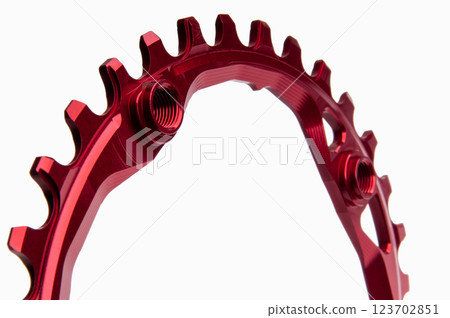 Close up of a red oval bicycle chainring against white isolated background, lies flat on the surface. Professional bicycle part. 123702851
