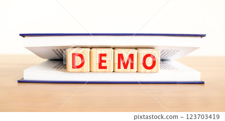 Demo symbol. Concept word Demo on beautiful wooden blocks in book. Beautiful wooden table white background. Business and demo concept. Copy space. Demo symbol. Concept word Demo on beautiful wooden blocks in book. Beautiful wooden table white background. Business and demo concept. Copy space. 123703419