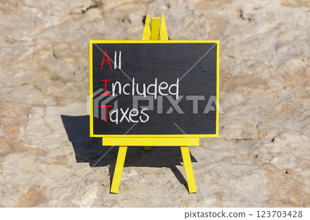AIT All included taxes symbol. Concept words AIT All included taxes on beautiful yellow blackboard. Beautiful stone background. Business AIT all included taxes concept. Copy space. 123703428