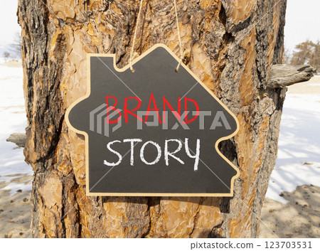 Brand story branding symbol. Concept words Brand story on beautiful yellow chalk blackboard. Beautiful old tree and sand background. Business brand story branding concept. Copy space. Brand story branding symbol. Concept words Brand story on beautiful yellow chalk blackboard. Beautiful old tree and sand background. Business brand story branding concept. Copy space. 123703531