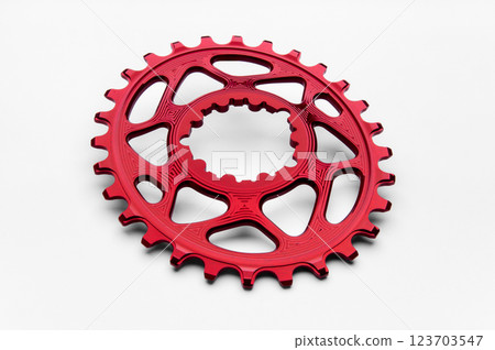 Red oval bicycle chainring against white isolated background, lies flat on the surface. Professional bicycle part. 123703547