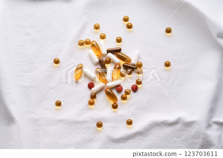 Vitamins and supplements on a white cotton background. 123703611