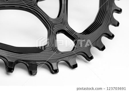 Close up of a black oval bicycle chainring against white isolated background. Professional bicycle part. 123703691