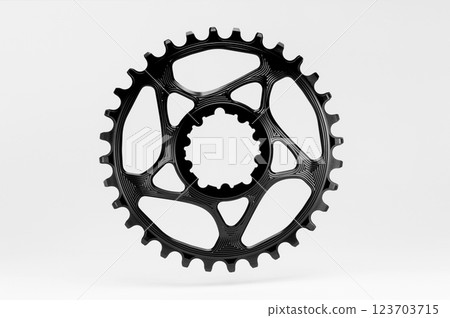 Black round bicycle chainring against white isolated background, floating above the surface. Professional bicycle part. 123703715