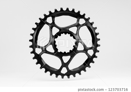 Black round bicycle chainring against white isolated background, floating above the surface. Professional bicycle part. 123703716